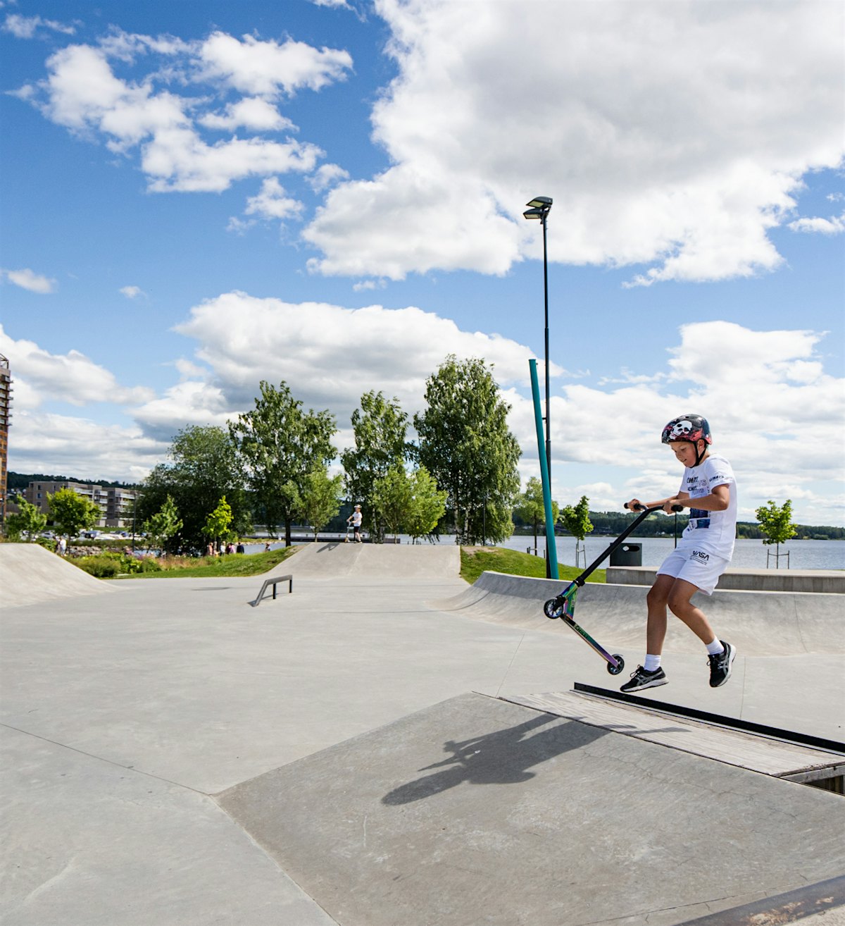 Junge auf Roller im Skatepark. Foto