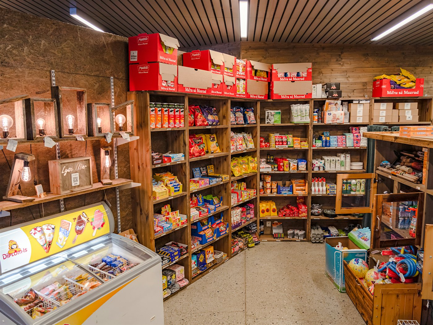 Überblick über den Laden im Topcamp Hallingdal, mit Ladenregalen gefüllt mit Eis, Süßigkeiten, Snacks, Lebensmitteln und Hygieneprodukten. Foto