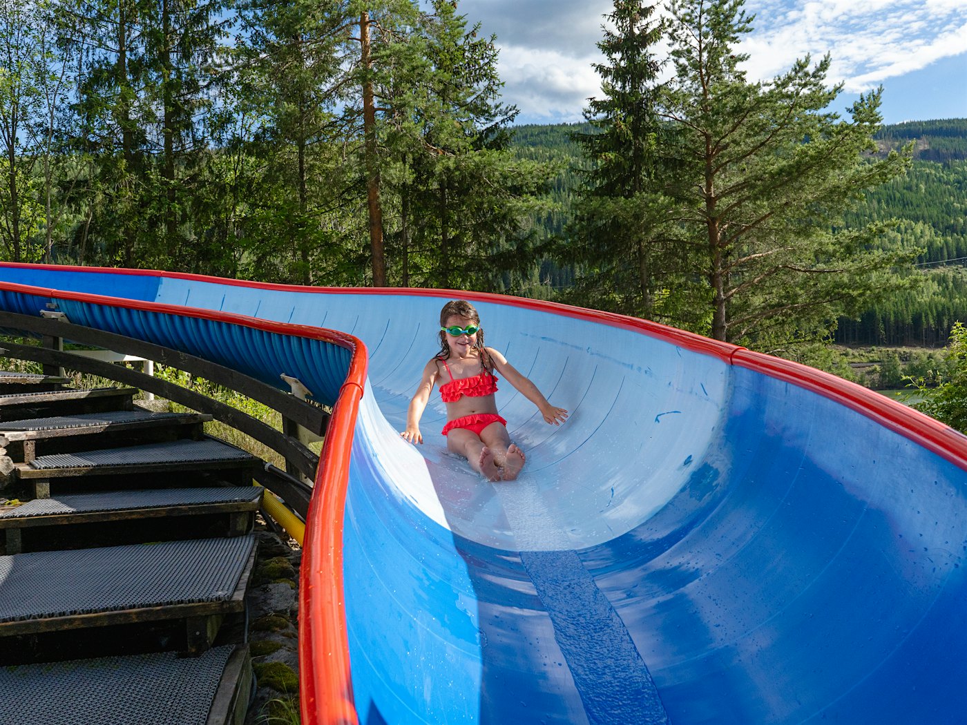 Girl slides down a large water slide. Photo