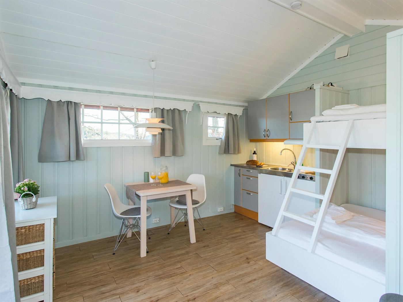 Helles Zimmer mit Etagenbett für die Familie, Esstisch und Küchenzeile. Foto