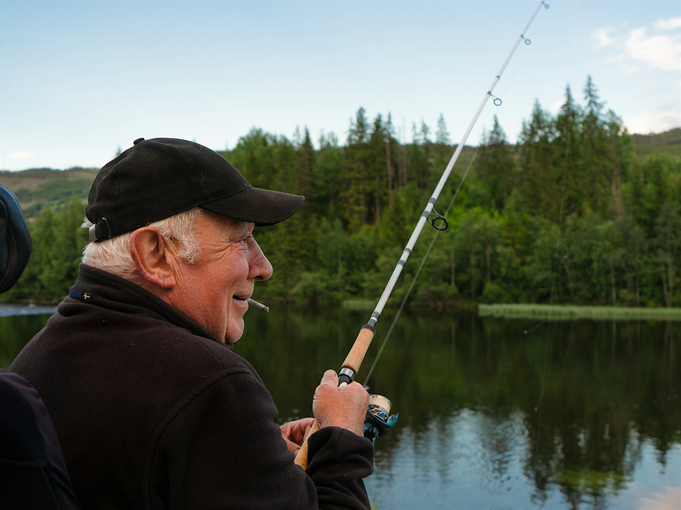 En mann med sigar fisker i Hallingdalselva. Foto