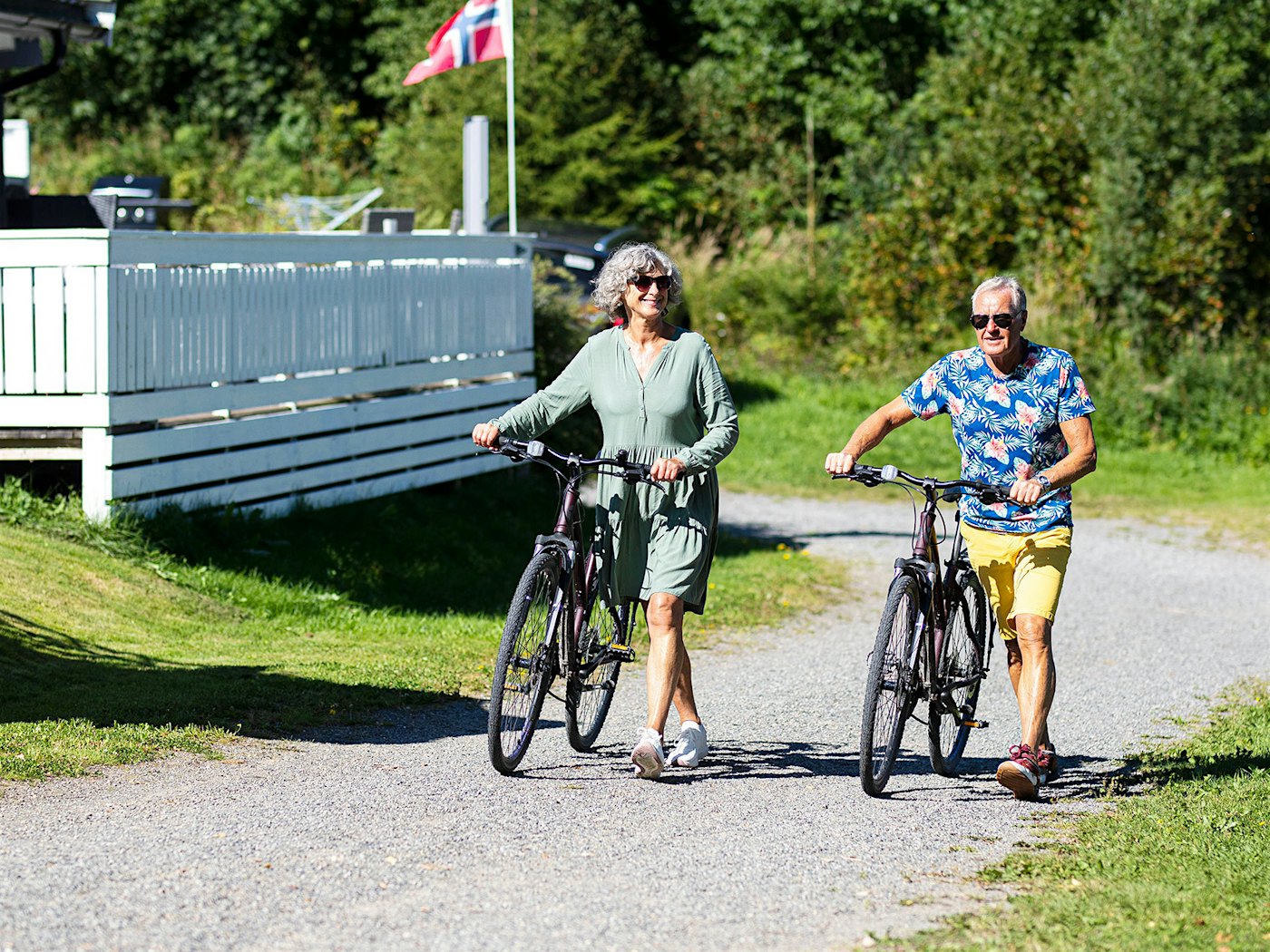 Ein älteres Ehepaar radelt in der Sommersonne auf einem Feldweg beim Topcamp Mjøsa. Foto