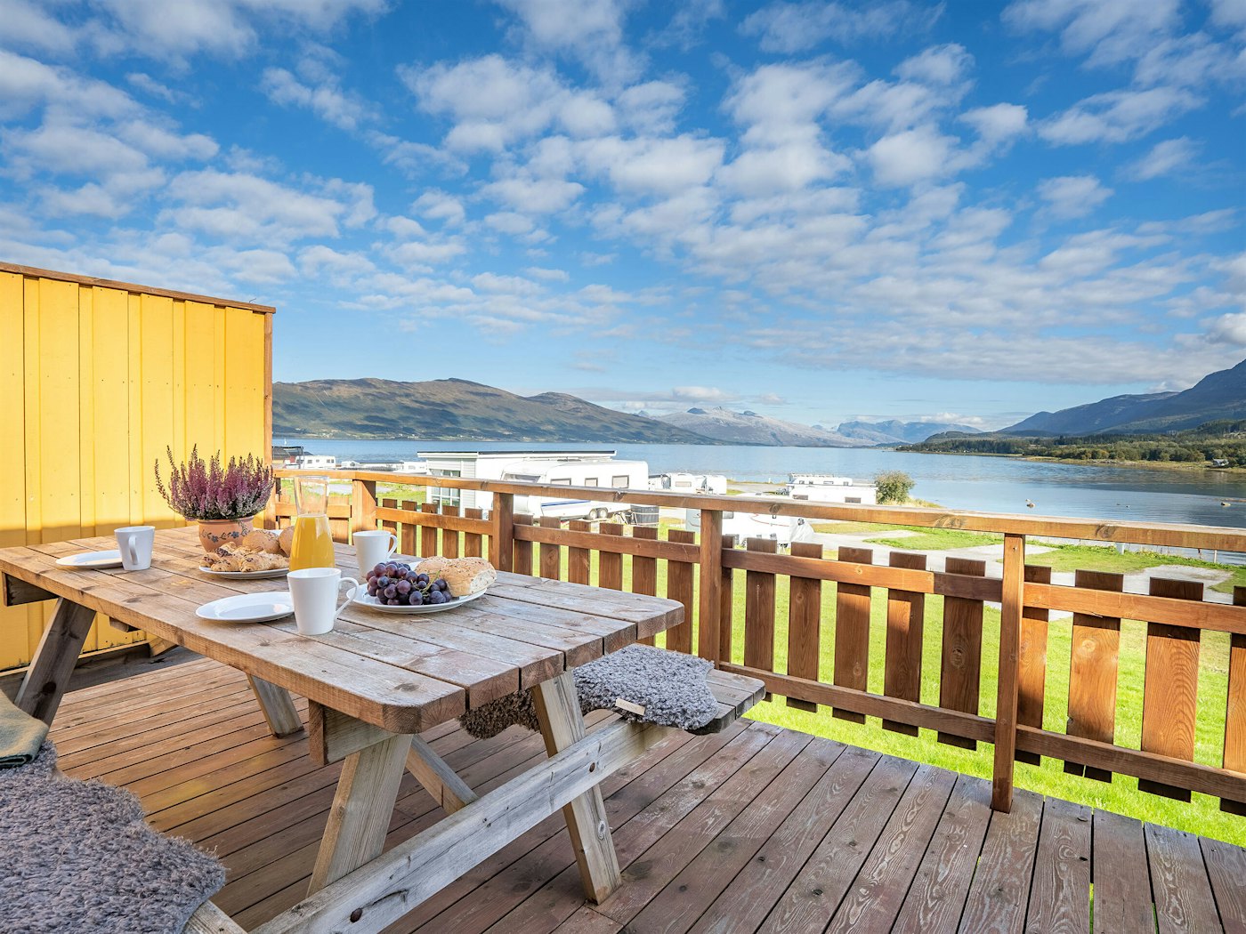 Terrasse mit gedecktem Frühstückstisch. Schönes Wetter und Blick auf das Meer und die Berge. Foto