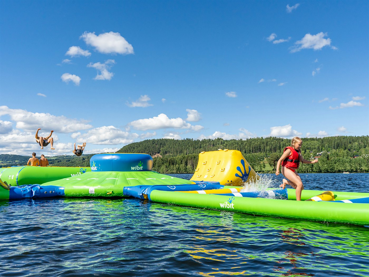 Kinder spielen und haben Spaß im schwimmenden Wasserpark in Mjøsa.