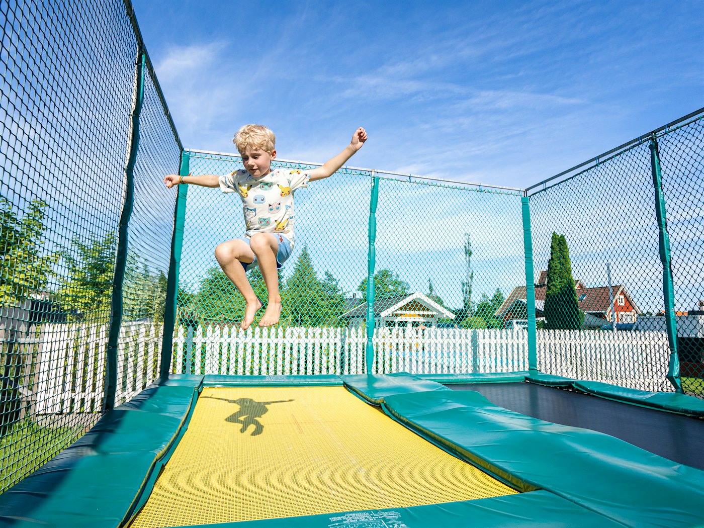 En gutt hopper på trampoline. Foto