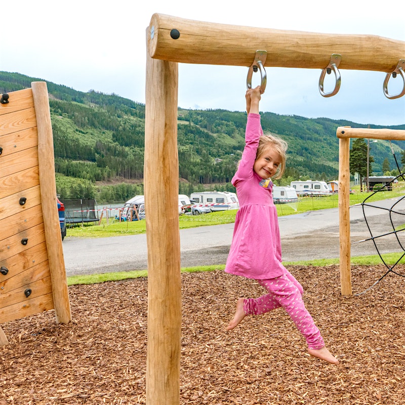 Girl playing in a climbing frame with pink clothes. Photo
