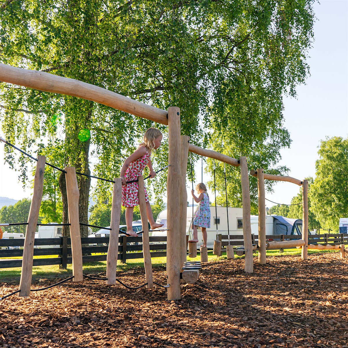 Two girls climb a play stand. Photo