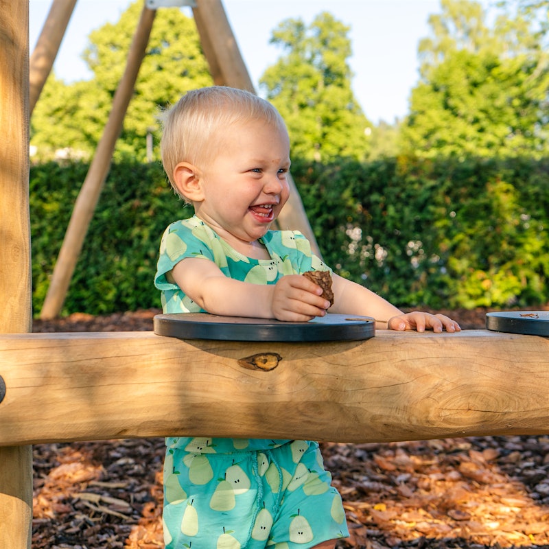 Junge lächelt breit, während er auf dem Spielplatz ist. Foto
